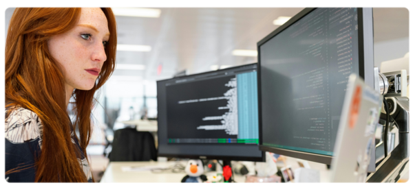 A programer sits at a computer station